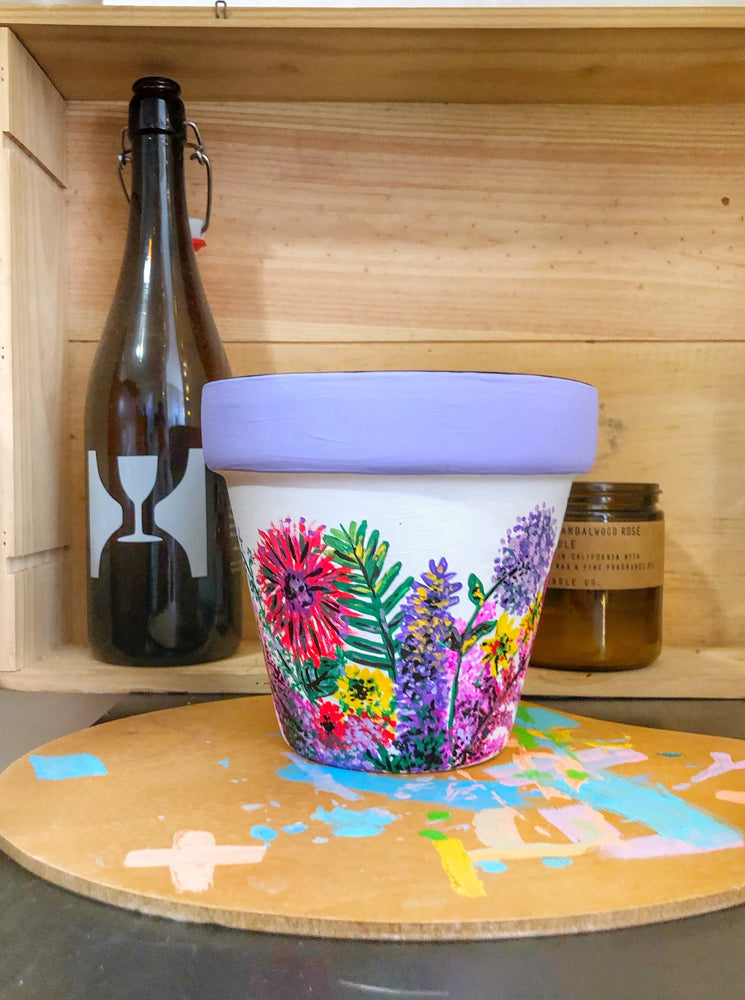 
                
                    Load image into Gallery viewer, My “Wildflower&amp;quot; hand painted terracotta planter illustrates some of my favorite funky fresh flowers in non-traditional colors.
                
            